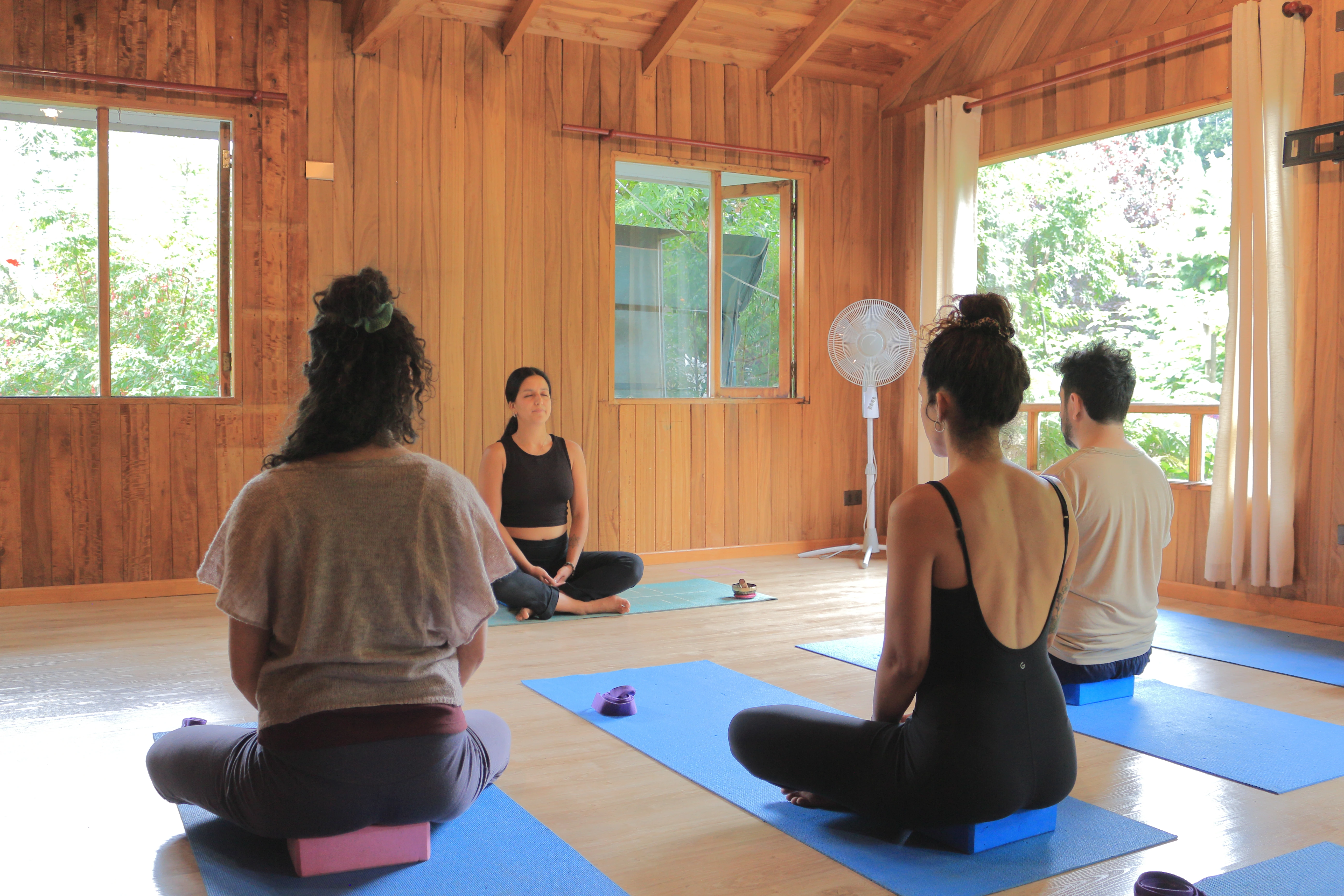 Personas meditando en una clase de Yoga